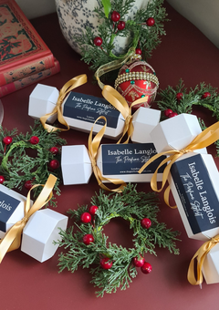Luxury Perfume Christmas crackers, tied with gold ribbons and styled with festive greenery and red berries, elegant handmade gifting. for her and him.