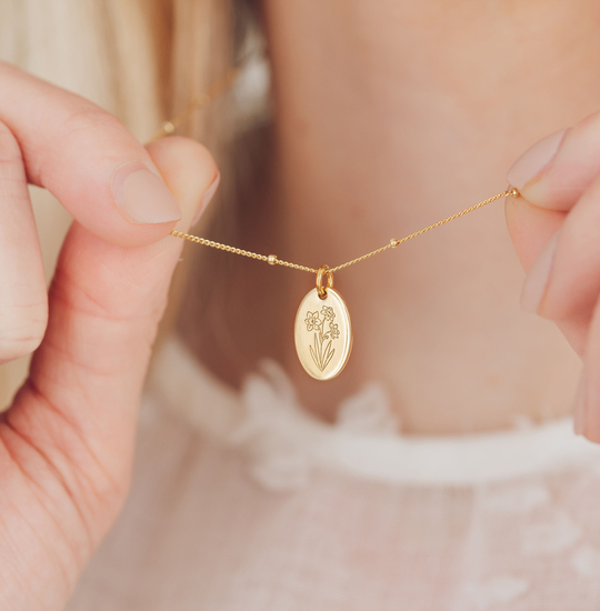 Gold birth flower necklace worn on chain