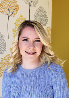 Image of a girl with blonde hair wearing a baby blue jumper.