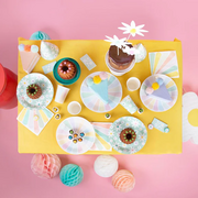 Yellow party table with pastel plates, cups and napkin decorations