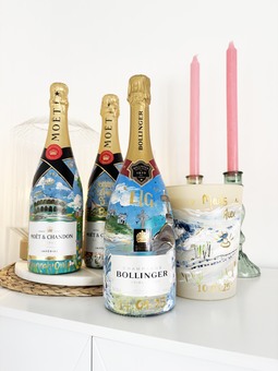 Custom hand-painted wedding gifts: bottles, candles, and keepsakes illustrating couples' unique love stories with venues, florals, and special dates.