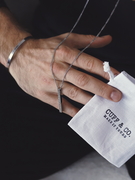 man holding a necklace and gift bag from cuff & co.