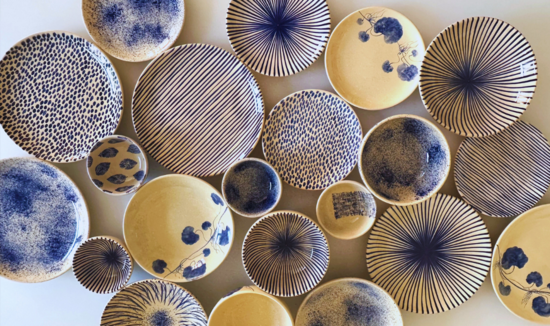 Top shot of plates and bowls sitting on a white table. Different blue patterns on each