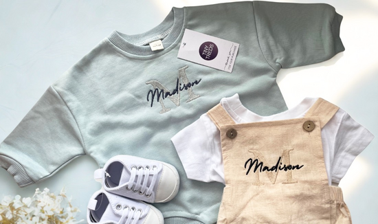 Blue Sweatshirt Romper and Beige Dungaree Romper. A pair of white baby shoes.