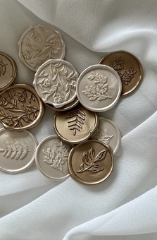 Handmade wax seals in gold and champagne colours with floral and foliage designs