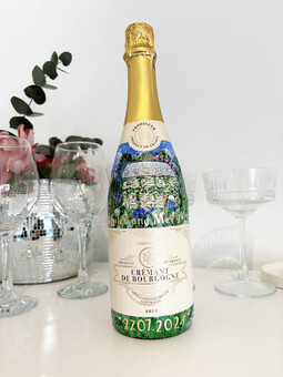 Hand-painted champagne bottle depicting a couple's love story with wedding venue, floral designs, names, and wedding date—unique personalised wedding gift.