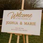 personalised wedding welcome sign made fromm wood which sits on a wooden easel. The sign is personalised with the couples names, wedding date and wedding venue